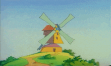 a windmill is sitting on top of a grassy hill