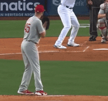 a baseball player with the number 45 on his jersey is standing on a base .