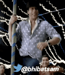 a man in a polka dot shirt is dancing on a carousel with the twitter hashtag @bhibatsam below him