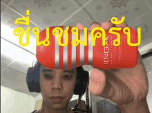 a man wearing headphones is holding a red tenga product