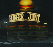 a burger joint is lit up at night with a hamburger on top