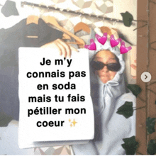 a woman holding a sign that says je m 'y connais pas en soda mais tu fais petiller mon coeur