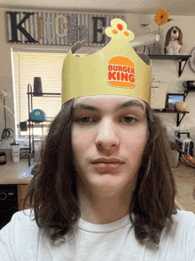 a young man wearing a burger king crown on his head