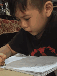 a boy wearing a black shirt with a red world map on it