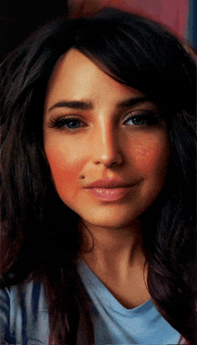 a close up of a woman 's face with a blue shirt