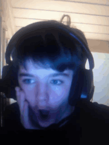 a young boy wearing headphones with a surprised expression on his face