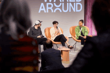 a group of people are sitting in front of a screen that says around