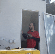 a man wearing a red shirt is using a drill