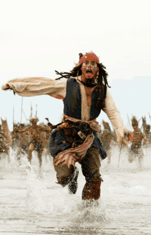 a man in a pirate costume is running through a body of water