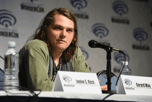 a man sitting at a table with a name tag that says jamie s. rich and gerard way