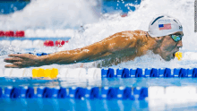 a man is swimming in a pool wearing a swim cap that says ' michael phelps ' on it