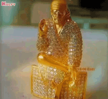 a gold statue of a man holding a briefcase covered in diamonds