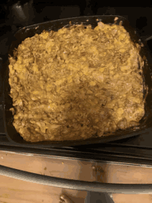 a casserole dish filled with a thick yellow sauce and tomatoes