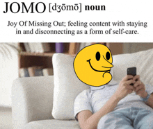 a man laying on a couch with a smiley face in front of him and the word jomo