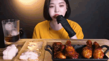 a woman wearing black gloves is eating a piece of meat