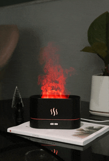 a black box with red smoke coming out of it sits on a table