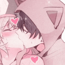 a boy and a girl are kissing each other in a cat hoodie .