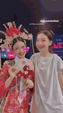 two girls are posing for a picture in front of a sign that says bnk48official