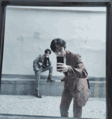 a man in a suit is taking a picture of himself in the mirror