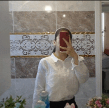 a woman in a white shirt is taking a picture of herself in the mirror