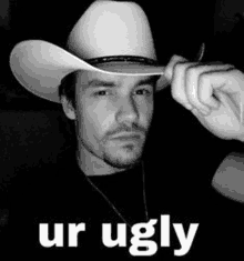 a black and white photo of a man wearing a cowboy hat with the words `` ur ugly '' .