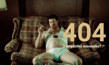 a man in underwear sits on a couch with a cigarette and a glass of whiskey