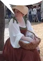 a woman in a straw hat is holding a basket in her lap .