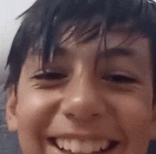 a close up of a young boy 's face with a smile on his face