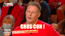 a man in a red shirt says gros con in front of a crowd of people