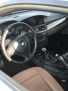 the inside of a bmw with a steering wheel and a radio