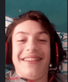 a young man wearing headphones smiles for the camera