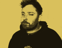 a close up of a man 's face with a yellow background and a black hoodie that says ' a '