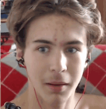 a close up of a young man 's face wearing headphones