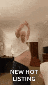 an older man is dancing in a living room with his shirt off and his belly exposed .