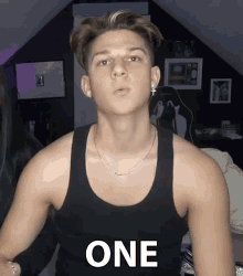 a young man in a black tank top with the word one on it