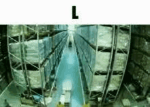 a warehouse filled with lots of shelves and boxes and a person walking through it .