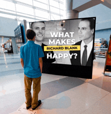 a boy stands in front of a large screen which says what makes richard blank happy