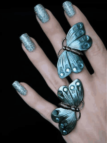 a close up of a woman 's hand with a butterfly ring