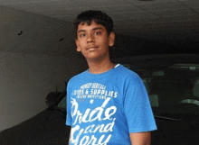 a young man wearing a blue shirt that says pride and glory