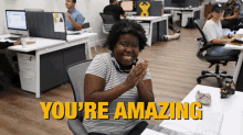 a woman clapping in an office with the words you 're amazing