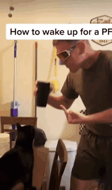 a man wearing sunglasses is holding a cup in his hand while a cat sits on a chair .