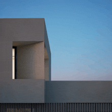 a building with a balcony and a blue sky in the background