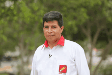 a man wearing a white shirt with a red collar and a pencil on it that says " peru libre "