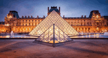 a large glass pyramid in front of a building