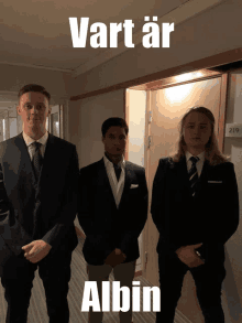 three men in suits are standing in a hallway with the words vart ar albin on the top