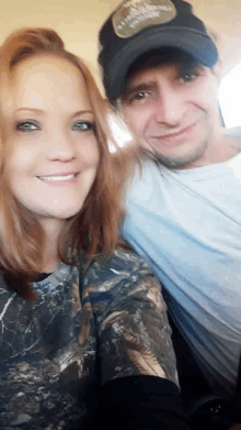 a man and a woman are posing for a picture and the man is wearing a hat that says ' alabama '