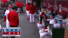 a group of baseball players standing in a dugout with a scoreboard that says happy mother 's day on it