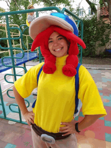 a woman wearing a yellow shirt and a red lobster hat