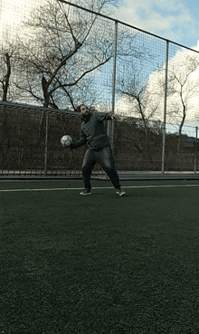 a man is holding a soccer ball in his hands on a field