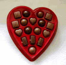 a heart shaped box filled with chocolates in various shapes